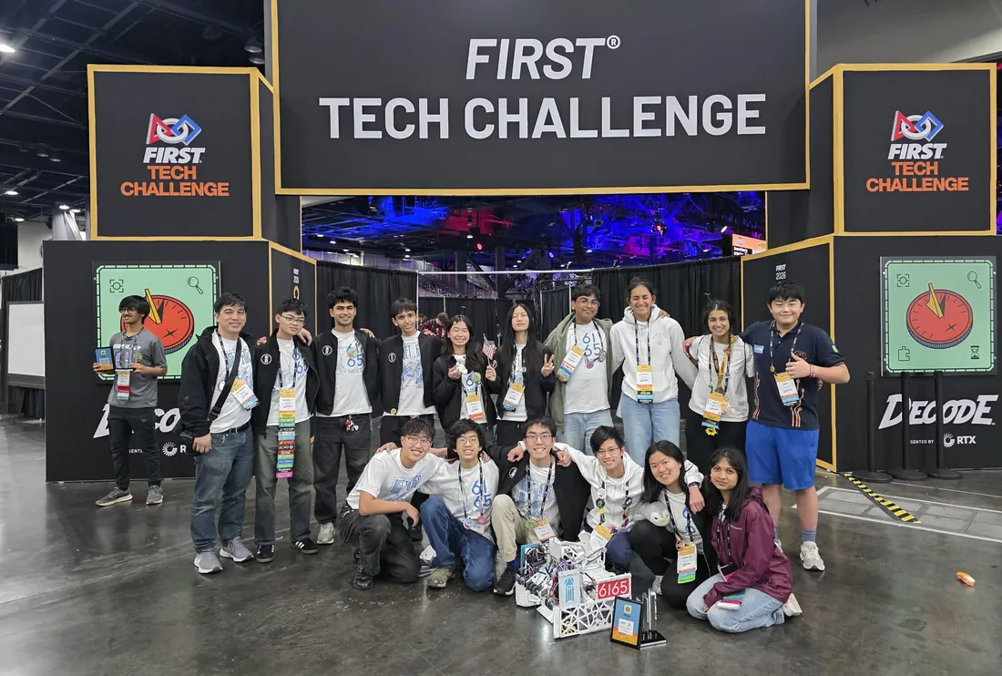 About twenty students of team 6165 MSET Cuttlefish gathered with their competition robot and awards under the FIRST Tech Challenge sign at the World Championship.